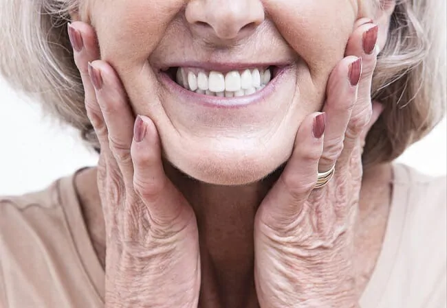 mature woman holding her face and smiling