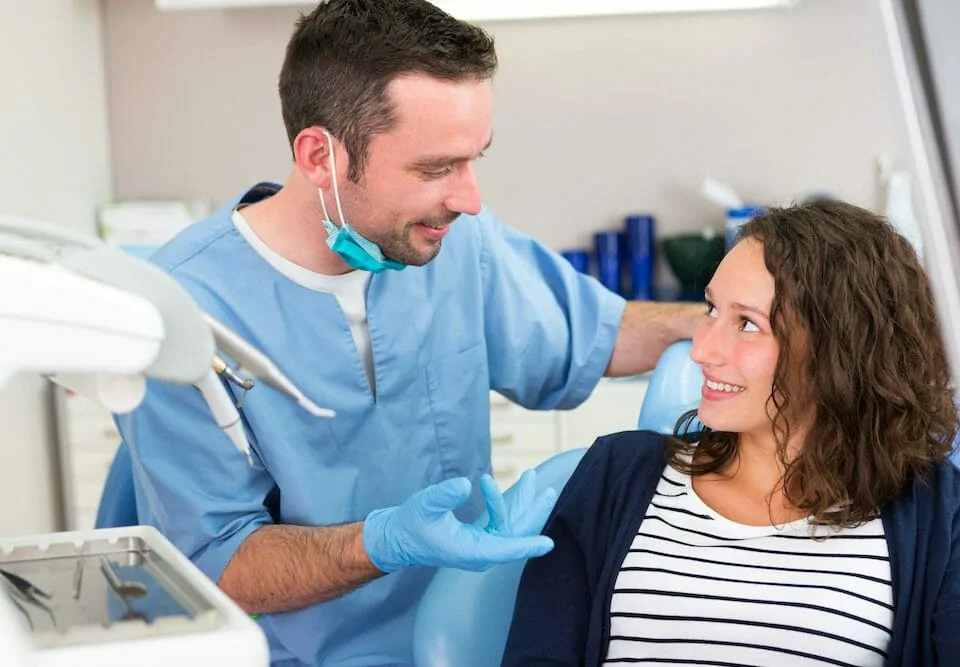 dental team member talking to a patient at visit