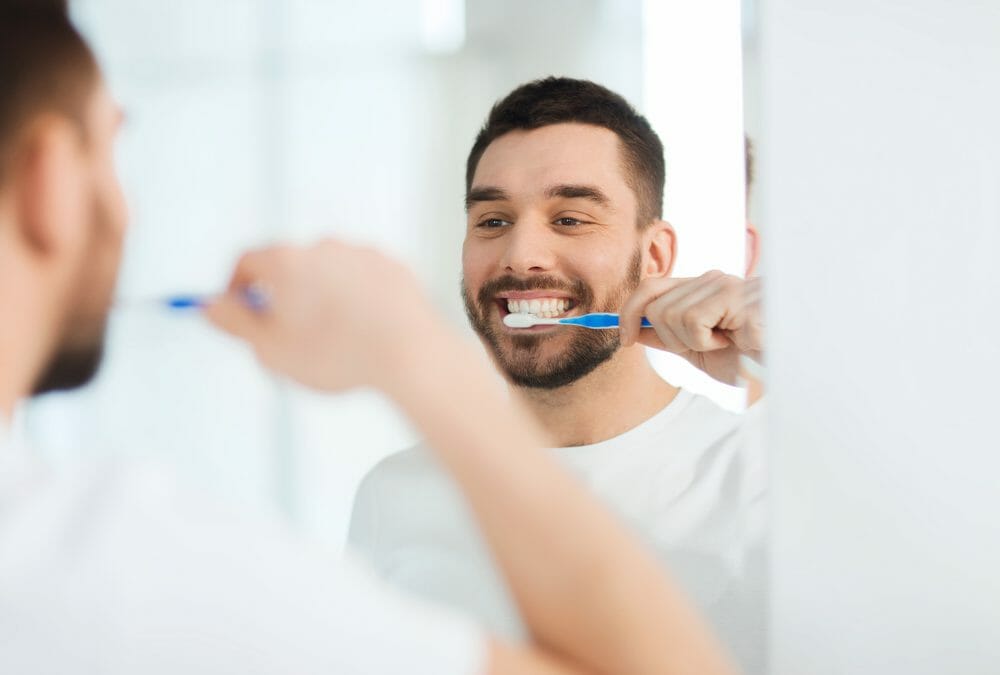 young man brushing his teeth