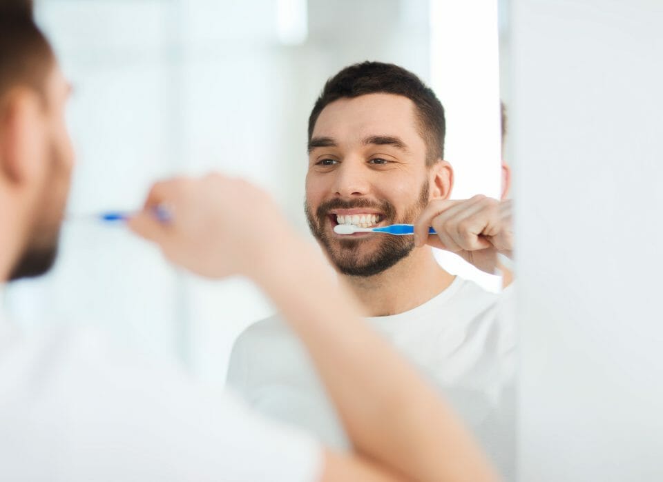 young man brushing his teeth