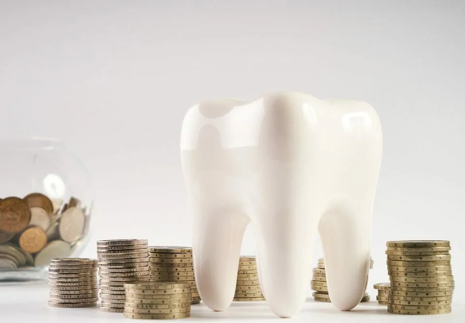 tooth next to stacks of coins