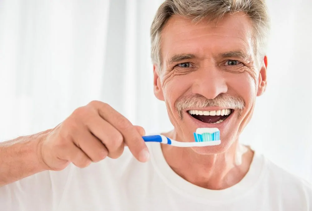 mature man brushing his teeth