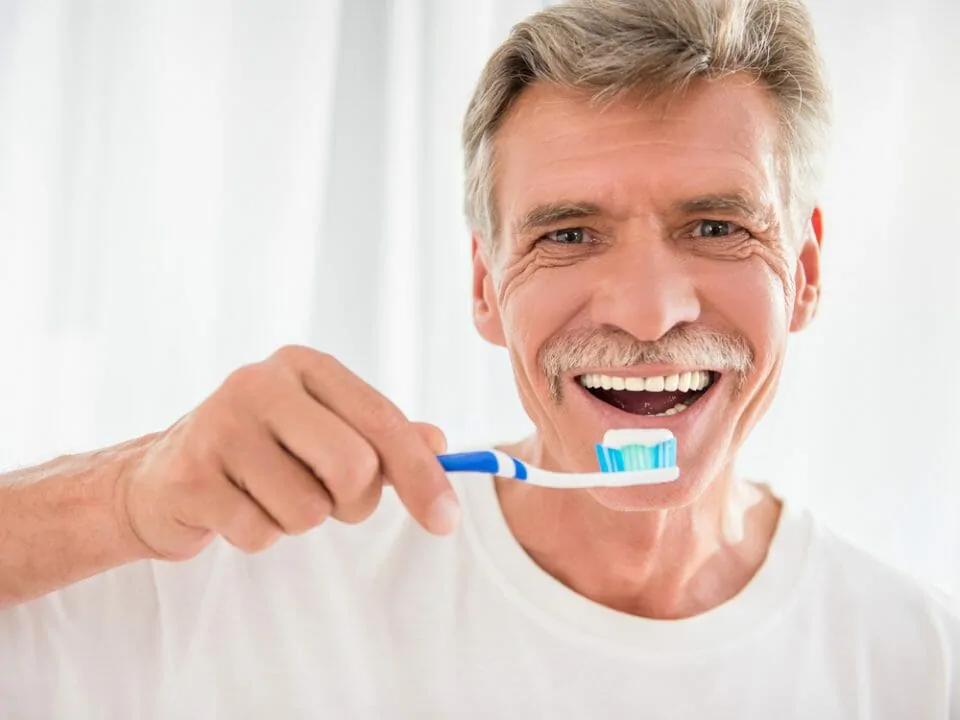 mature man brushing his teeth