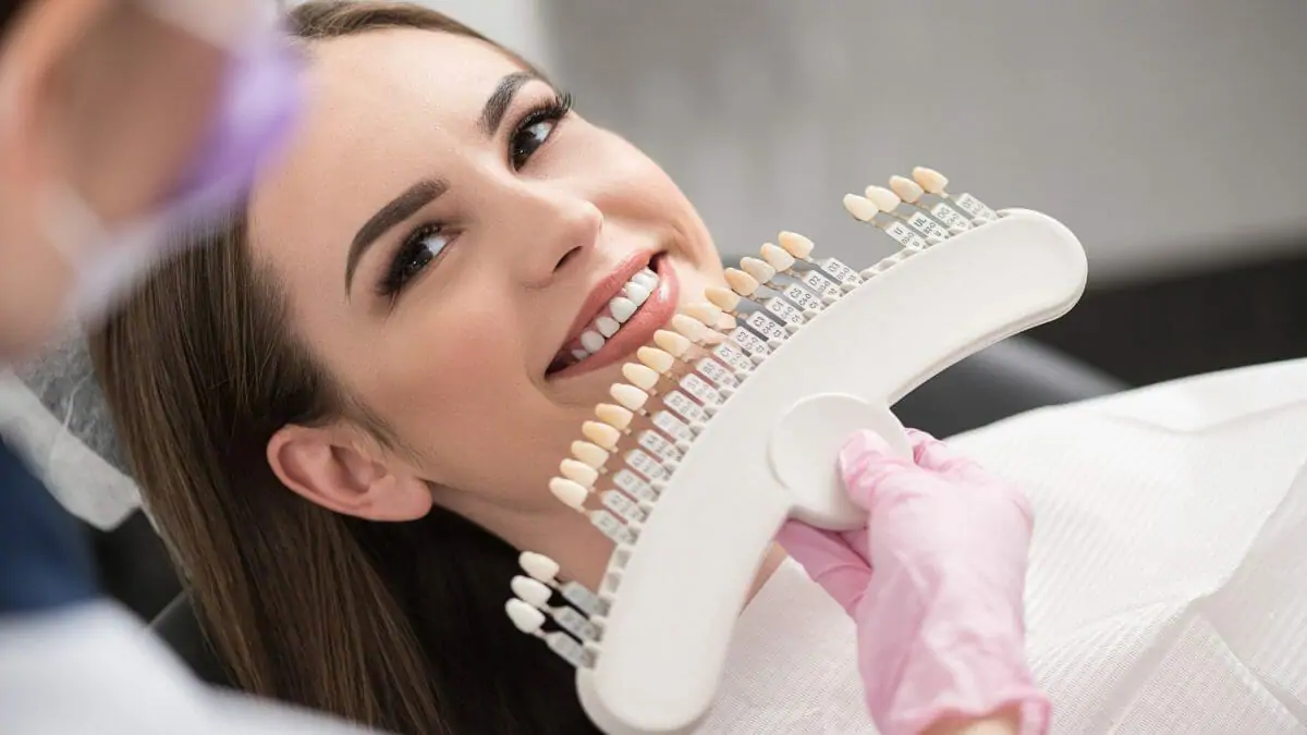 woman comparing teeth coloring at the dentist