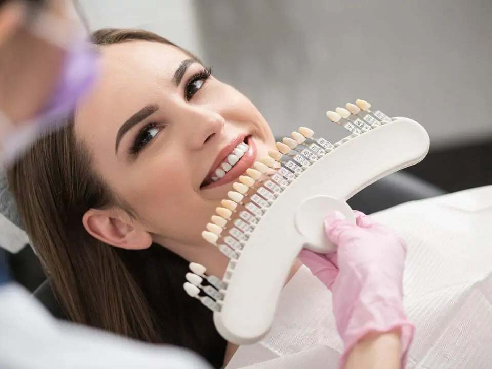 woman comparing teeth coloring at the dentist