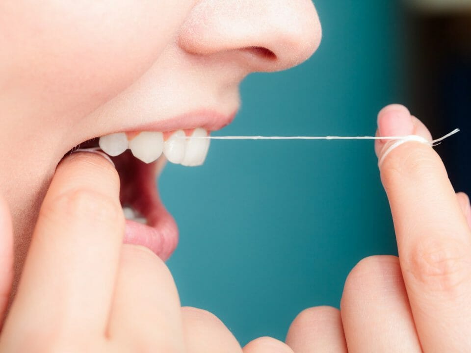 Woman flossing her teeth