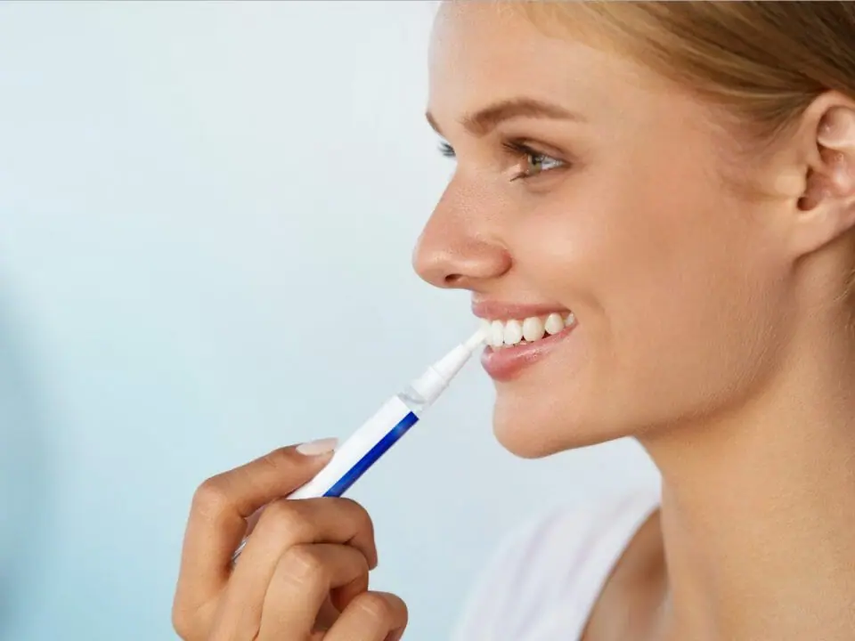 Woman using whitening pen