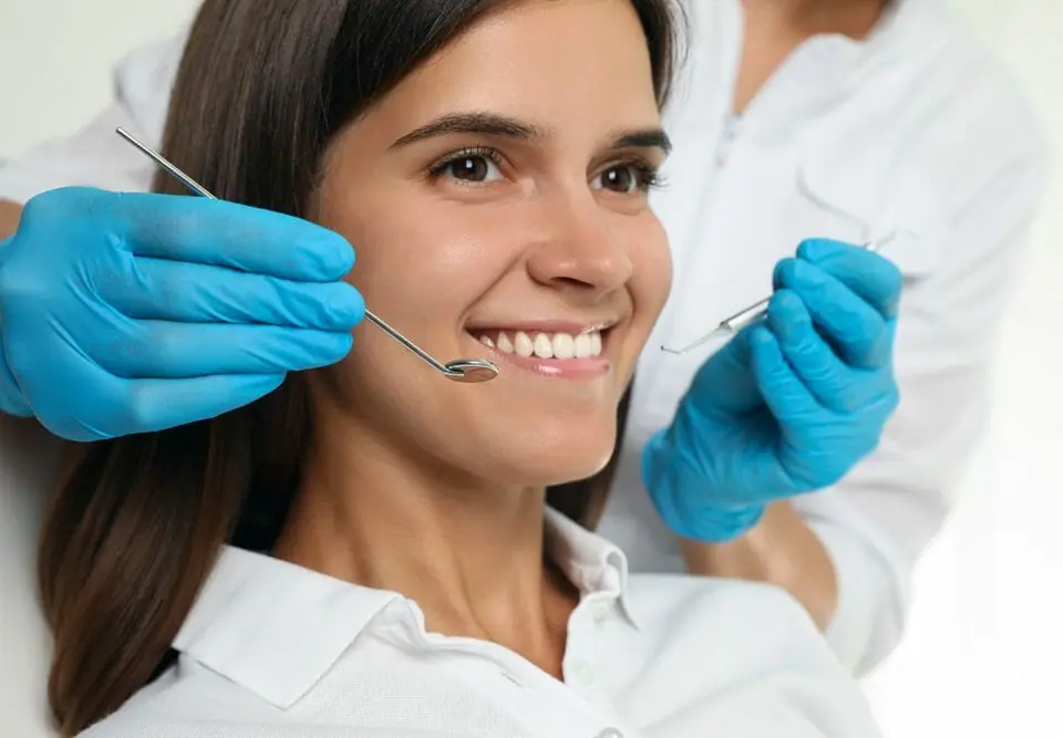 Woman Smiling with Dental Tools by Her Face